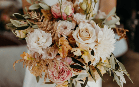A wedding bouquet in oranges and faded pinks