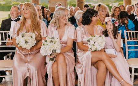 wedding flowers happy guests sat at a ceremony